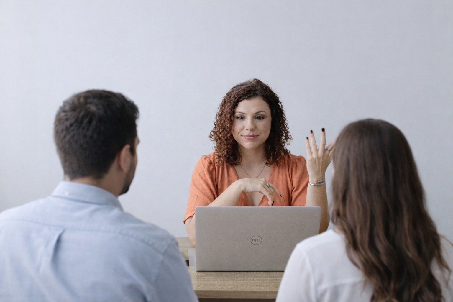 Psicóloga de Ribeirão Preto atendendo casal em consultório, com os pacientes sentados de costas enquanto recebem orientação durante sessão de terapia de casal.
